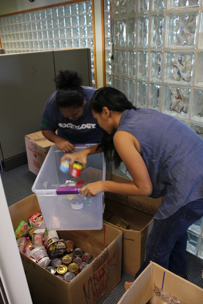 Sociology alumni Myotel Ngwal and Kayla Sablan sort canned goods that were distributed to Guma' San Jose last November 2014 as a service project.