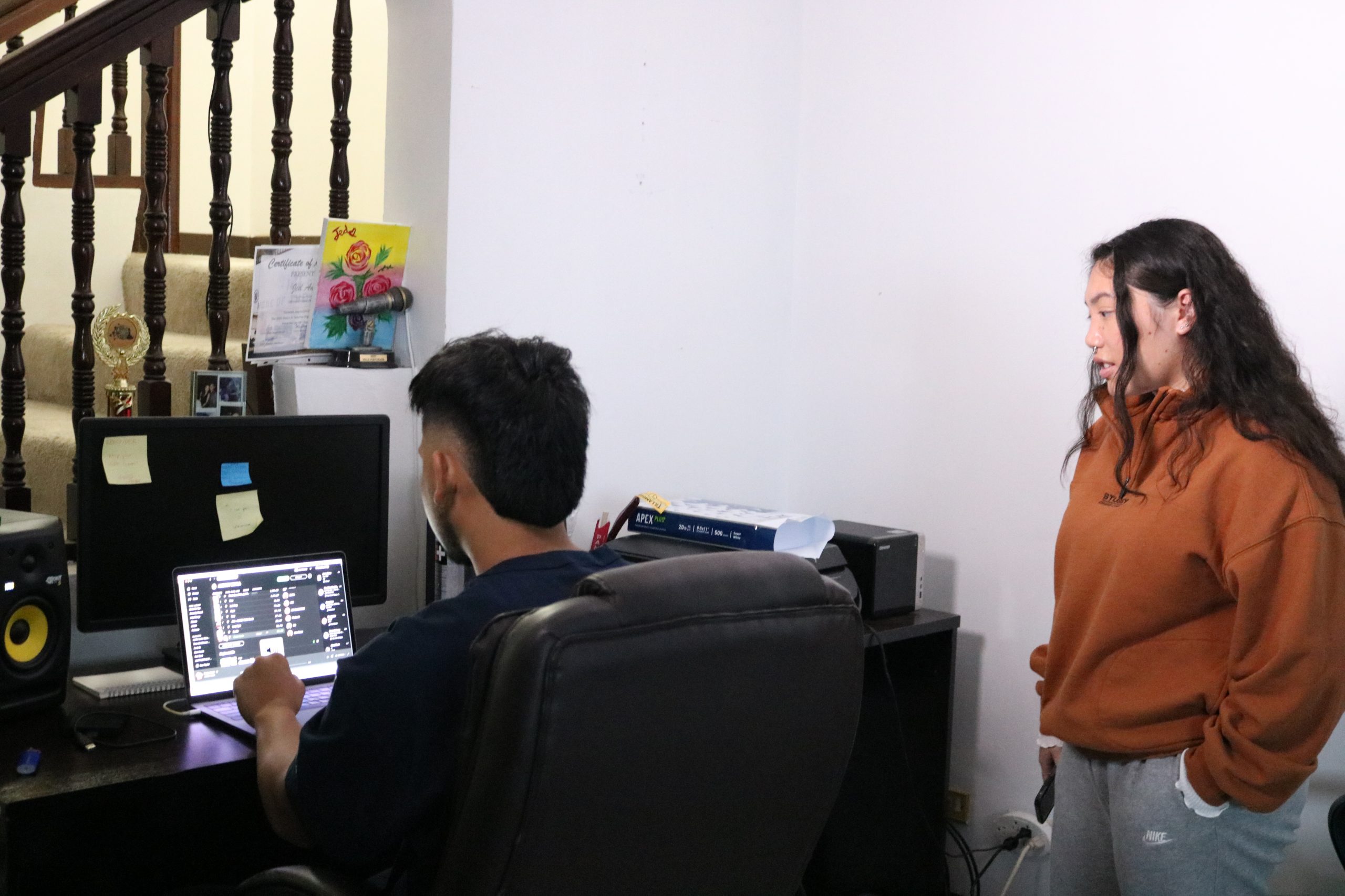 A photo of Harmony and her producer, Jed, listen to some of the artists they're inspired by at the Project Inspire production studio.